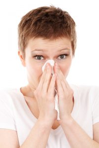 a woman with a tissue to her nose