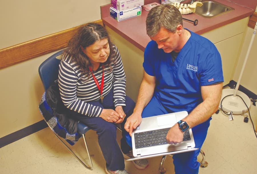 Neurosurgeon Explaining Information on Laptop to Patient