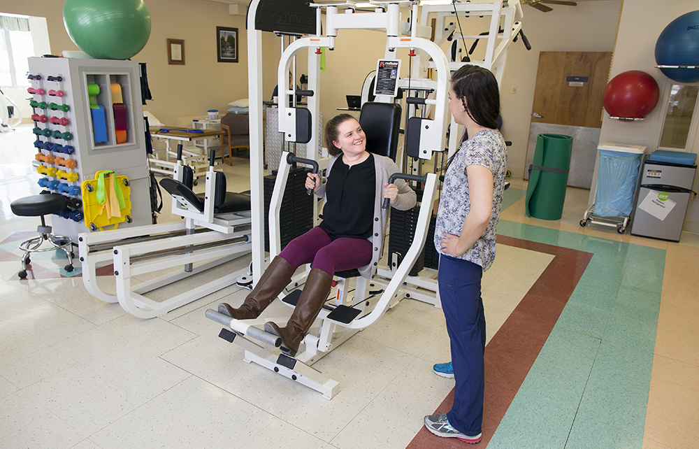 Woman in exercise machine talking to nurse