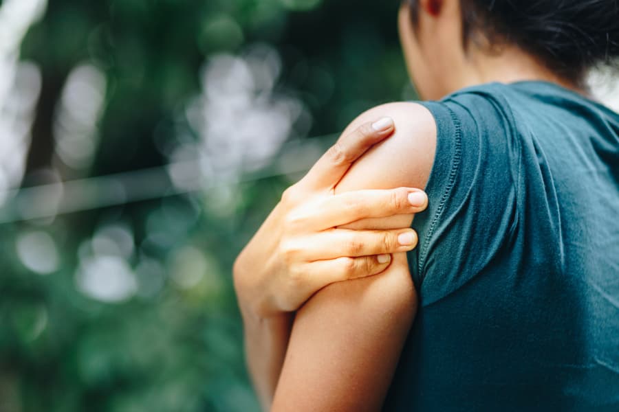 Woman holding shoulder in pain