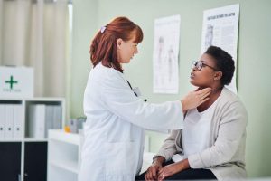 Doctor examining sick patient's throat